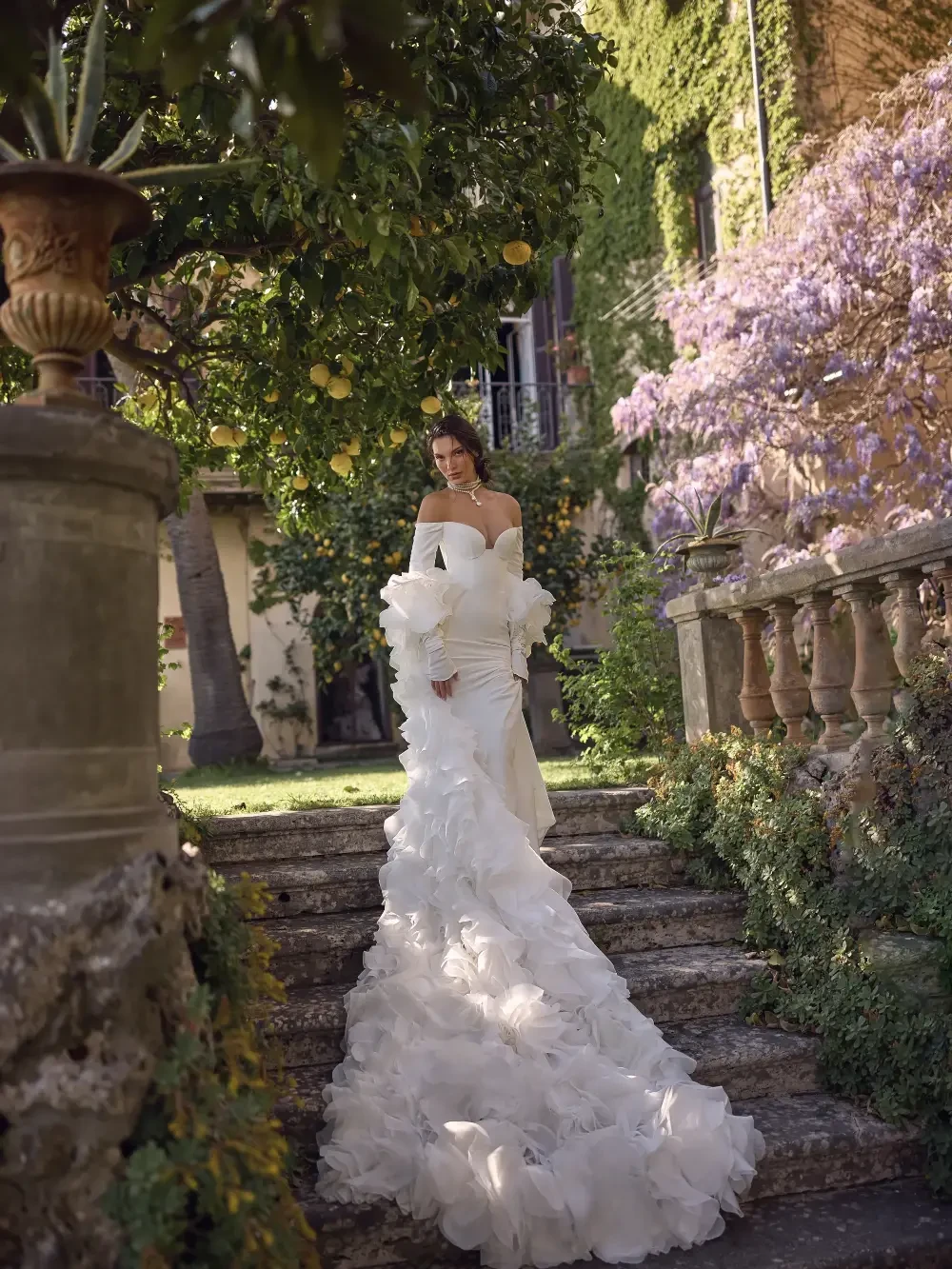 model is wearing a long sleeve off the shoulder wona concept bridal gown
