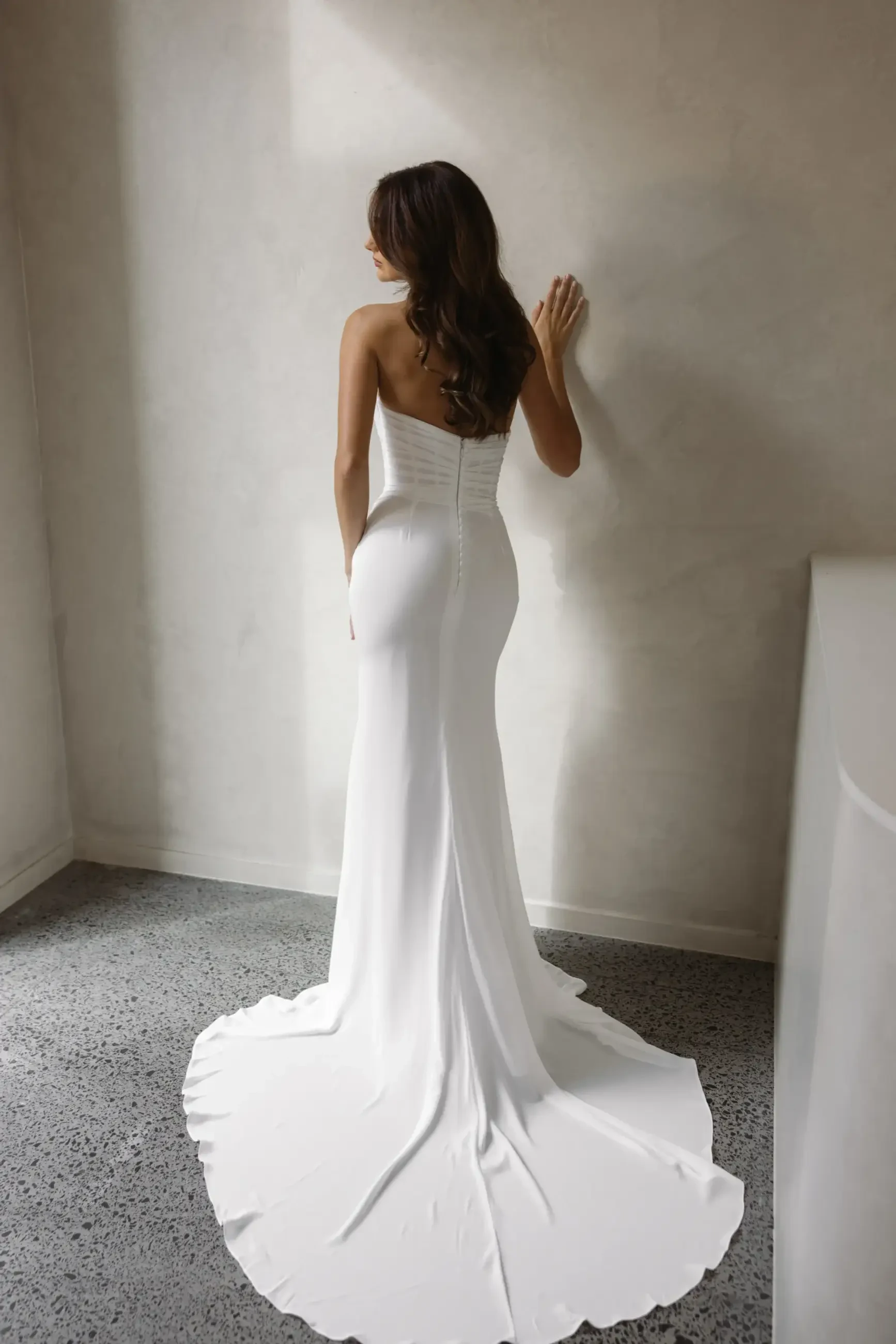 model is wearing a strapless fit and flare wedding dress with a neck scarf