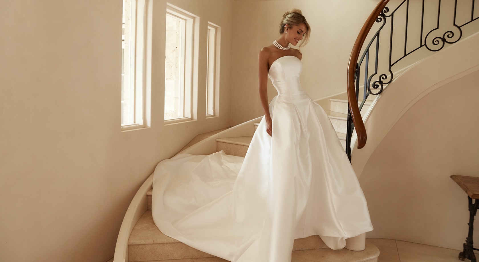 Model wearing a gown and posing near the stairs