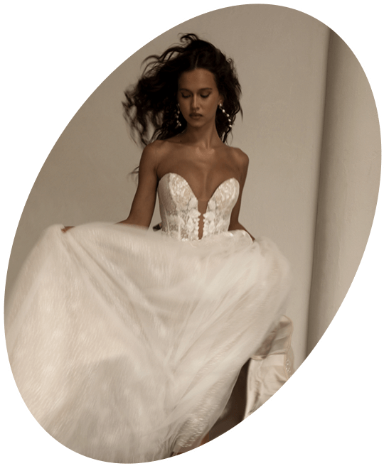 Photo of the model wearing bridal gown and posing near the water