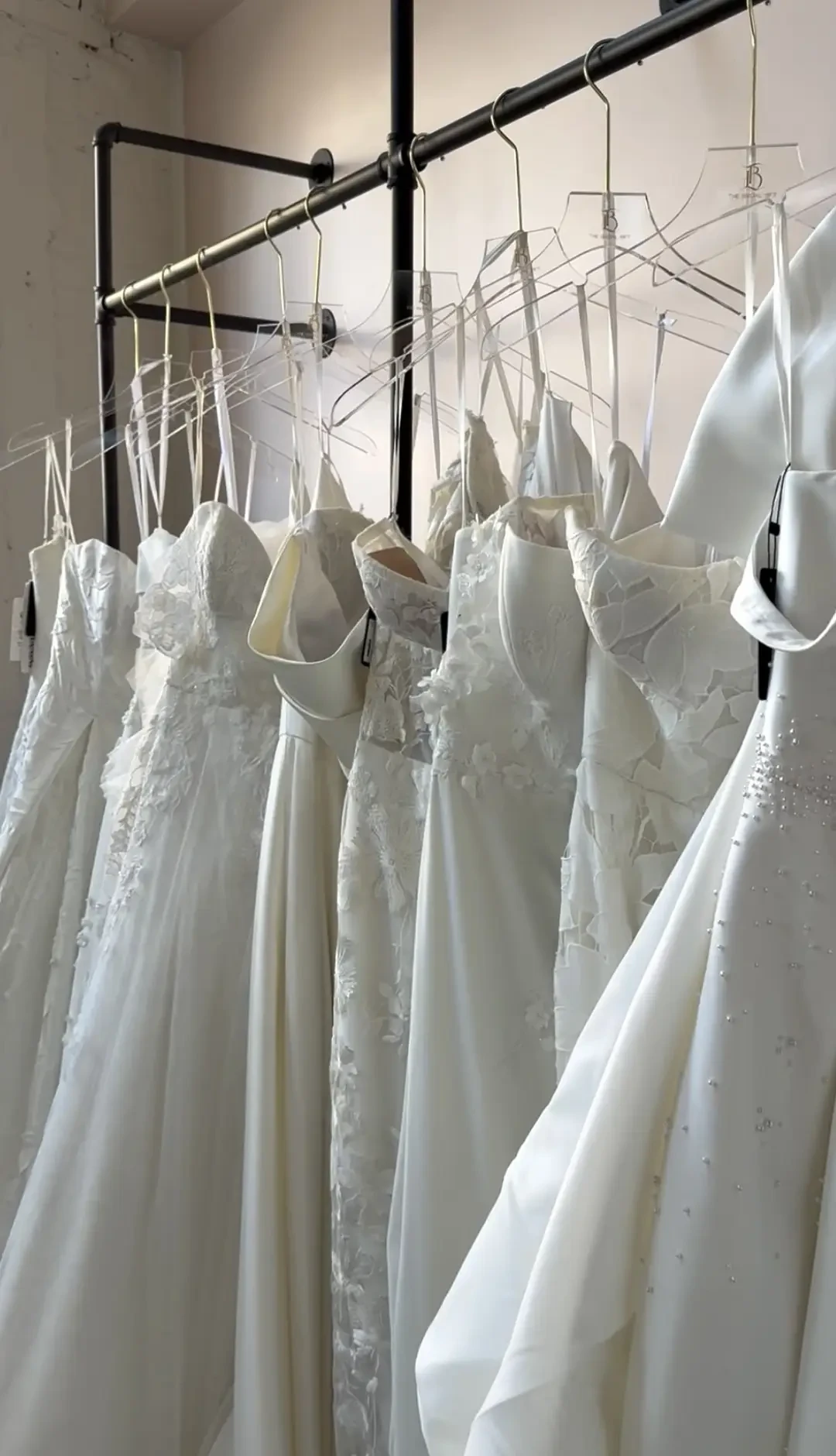 image shows a rack of wedding gowns hanging up
